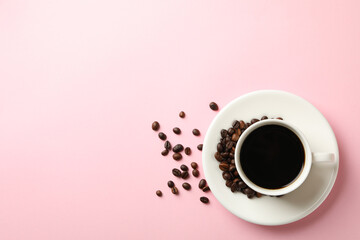 Cup of coffee and beans on pink background