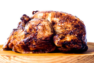 Roast chicken on a wooden tray on white background