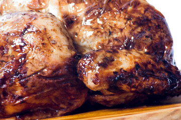 Roast chicken on a wooden tray on white background