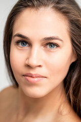Fototapeta premium Face portrait of young caucasian woman with natural make up and eyelash extensions looking at camera on white background