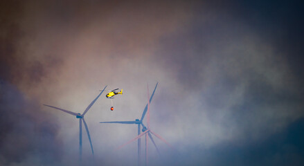 Smoke, windmill and helicopter flying with bambi-bucket