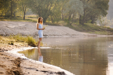 girl in a short bondage dress on the lake at dawn