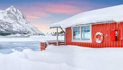 Wonderfull winter scenery with traditional Norwegian red wooden houses on the shore of Rolvsfjord on Vestvagoy island