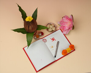 Red accounting note book / bahi khata with copper kalash, sweets, marigold, haldi kumkum, pen with...