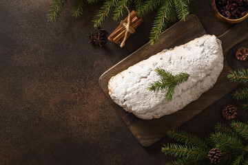 Christmas stollen - traditional German bread on brown background. Holiday pastry dessert. Copy space. View from above.