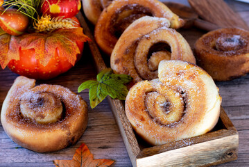 fresh baked cinnamon rolls with autumn decoration from above