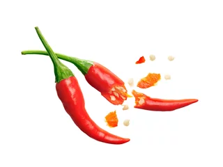 Abwaschbare Fototapete Scharfe Chili-pfeffer Samen platzen aus roten Chilischoten auf weißem Hintergrund