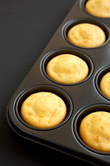 Homemade Cornbread Muffins on a black surface, low angle view. Copy space.