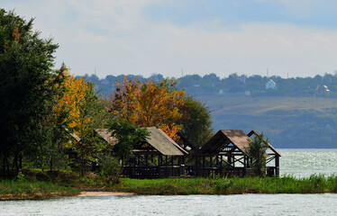 Obraz premium Autumn nature, wooden tents at the river, rest photo
