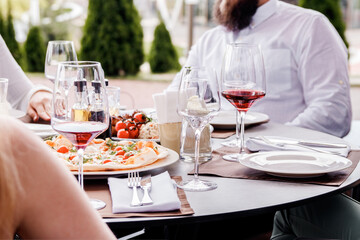 Served table for dinner. Group of friends enjoying meal at outdoor restaurant