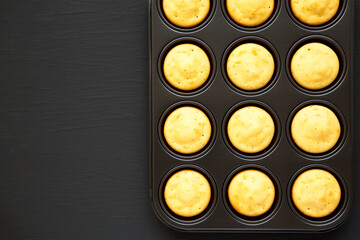 Homemade Cornbread Muffins on a black background, top view. Flat lay, overhead, from above. Copy space.