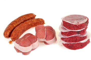 Saucisses fumées, paupiettes et steaks hachés crus sur fond blanc