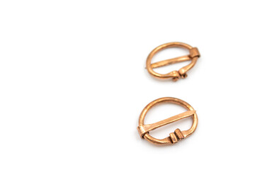 Isolated photos of a medieval copper fibula