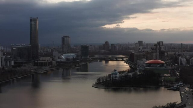 Panorama of the pond and Yekaterinburg Iset skyscraper. Stock footage. Aerial view of Dinamo building with round orange roof and the modern cityscape.
