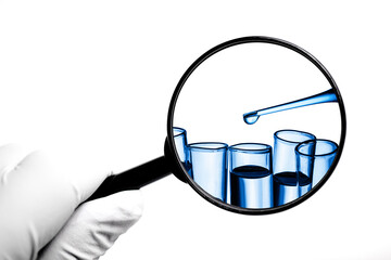 Hand in latex glove holding magnifying glass isolated on white background. Laboratory test tube....