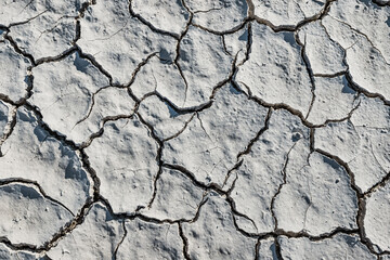 White soil cracked from the drought, top view. Background and texture to illustrate global...
