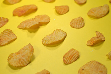 Potato crispy chips in geometry on yellow background