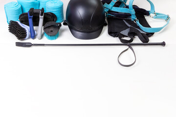 Flat lay of equestrian gear: helmet, brushes, whip, bandages, pads, dressage, bridle. Accessories...