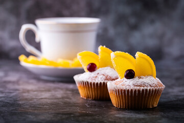 Cupcakes with slices of marmalade and cranberries on a gray background.