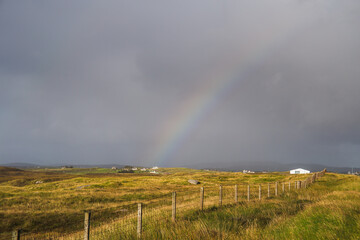 Dark skies and colourful rainbow over the hills of South Uist, Outer Hebrides, Scotland