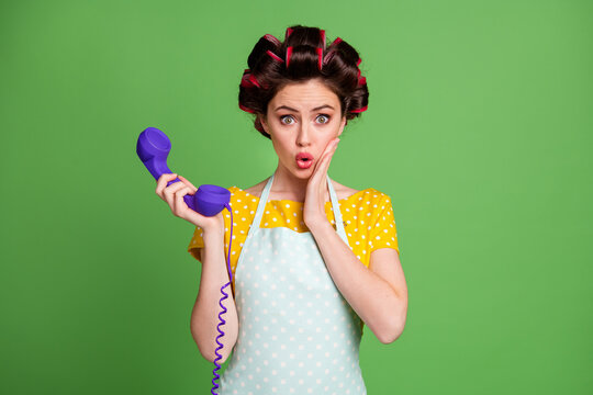 Photo astonished vintage girl call ring telephone cord impressed operator center news touch hand face wear yellow dotted dress skirt hair rollers isolated green color background