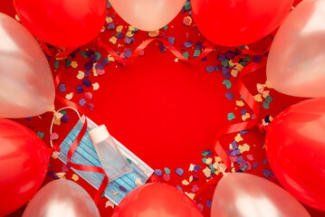 Party background with Coronavirus decorated with face mask, hydroalcoholic gel, balloons colored and confetti. Covid and party concept..