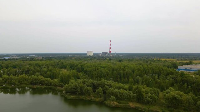 Aerial view over a river and forest, towards the TES 6 coal power plant, cloudy day, in Kiev, Ukraine - dolly, drone shot