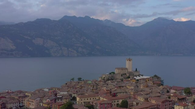 Descending aerial shot overlooking Scaligero Castle, Garda Lake and the surrounding mountains