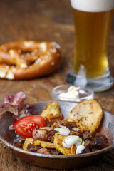 Kartoffelgröstl auf dunklem Holz