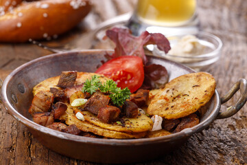 Kartoffelgröstl auf dunklem Holz