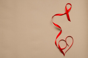 Top view of red ribbon and shape of heart.Concept of solidarity with people who leaves with hiv.Empty space