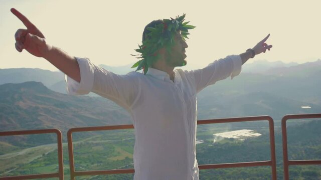 Giovane ragazzo laureato con corona di alloro in testa festeggia il suo traguardo