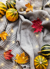 Pumpkins and a warm grey sweater with shining garlands.