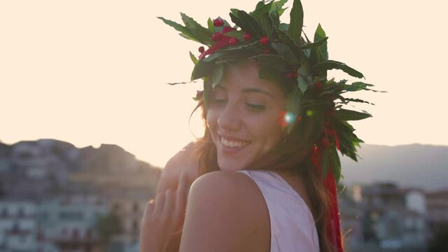 Giovane ragazza con vestito bianco si laurea. Corona di alloro in testa simbolo trionfale italiano.