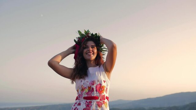 Giovane ragazza con vestito bianco si laurea. Corona di alloro in testa simbolo trionfale italiano.