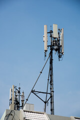 Cellular tower on rooftop with blue sky background