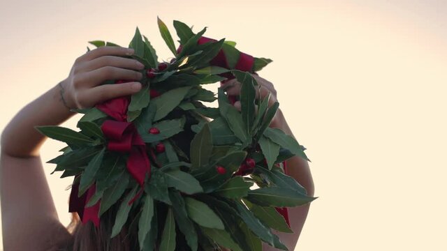 Giovane ragazza con vestito bianco si laurea. Corona di alloro in testa simbolo trionfale italiano.