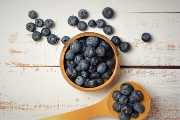 Blueberries on white wooden table and rustic utensils