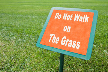 Do not walk on the grass - concept image white text on signboard and fresh green lawn