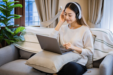 Fototapeta na wymiar Asian woman who put headphone on her head do work from home.