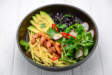 salad with avocado and shrimps in bowl, top view