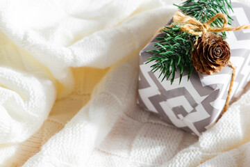 Close up Christmas gift box with fir twig and pine cone.