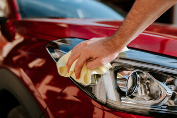 Man cleaning the car with yellow microfiber mop.