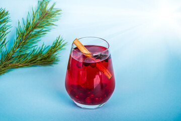 Christmas mulled red wine with spices on blue background. Cranberry drink with cinnamon and anise. Minimalism, copy space for text