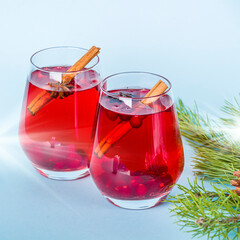 Christmas mulled red wine with spices on blue background. Cranberry drink with cinnamon and anise. Minimalism, copy space for text