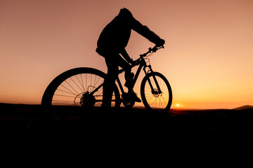 Fototapeta na wymiar the fit cyclist successful ride and watch the sun from the summit mountains