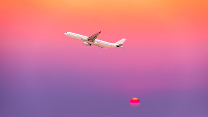 Commercial airplane flying above clouds in colorful sunset.Travel,holidays and business concept.
