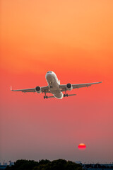 Commercial airplane flying above clouds in colorful sunset.Travel,holidays and business concept.