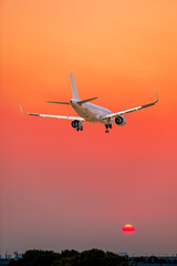 Commercial airplane flying above clouds in colorful sunset.Travel,holidays and business concept.