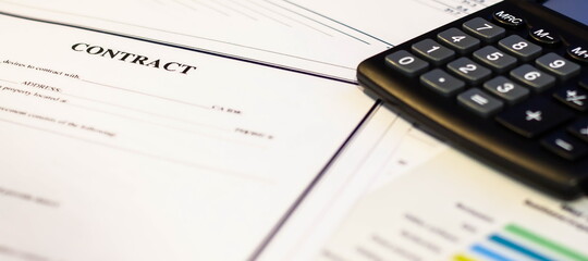 A contract document next to a calculator on a white table in the office.